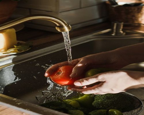 Fresh vegetables being washed under running water